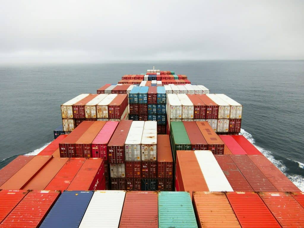 A cargo ship sails across the ocean, symbolizing the importance of knowing how to choose the best shipping method—ocean or air—for your cargo.